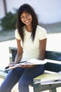 Female College Student Sitting On Bench With Book Royalty Free Stock Photo