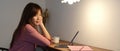 Female college student sitting at wooden counter bar and looking informations on digital tablet Royalty Free Stock Photo