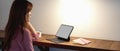 Female college student sitting at wooden counter bar and looking informations on mock-up digital tablet Royalty Free Stock Photo