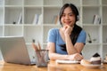 A female college student smiling at the camera while listening to music through her headphones Royalty Free Stock Photo