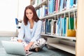 Female College Student Studying In Library With Laptop