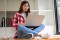 Female college student studying on online class, wearing earphones and using laptop Royalty Free Stock Photo