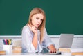 Female college student working on a laptop in classroom, preparing for an exam. Beautiful caucasian female student is Royalty Free Stock Photo