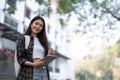 Female college students happily holding laptops outdoors after school on campus. when the sun goes down the horizon with Royalty Free Stock Photo