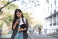 Female college students happily holding laptops outdoors after school on campus. when the sun goes down the horizon with Royalty Free Stock Photo