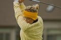Female collegiate golfer swinging golf club
