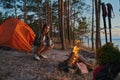 Female coming closer to campfire with mug of tea Royalty Free Stock Photo