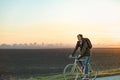 Female commuter riding a bike out of town in rural area. Young w Royalty Free Stock Photo