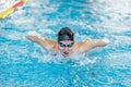 Female swimmer moving through the water performs a butterfly stroke Royalty Free Stock Photo