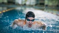 Female swimmer moving through the water performs a butterfly stroke Royalty Free Stock Photo