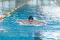 Female swimmer moving through the water performs a butterfly stroke Royalty Free Stock Photo