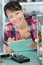 Female computer technician holding clipboard Royalty Free Stock Photo