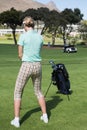 Female concentrating golfer teeing off Royalty Free Stock Photo