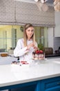 Female confectioner standing in the modern spacious kitchen, de