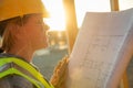 Female Construction Worker with House Plans at Construciton Site