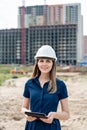 Female construction engineer. Architect with a tablet computer at a construction site. Young Woman look in camera Royalty Free Stock Photo