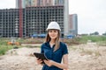 Female construction engineer. Architect with a tablet computer at a construction site. Young Woman look in camera Royalty Free Stock Photo