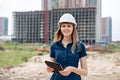 Female construction engineer. Architect with a tablet computer at a construction site. Young Woman look in camera Royalty Free Stock Photo