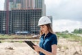 Female construction engineer. Architect with a tablet computer at a construction site. Young Woman looking, building Royalty Free Stock Photo