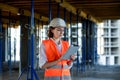 Female construction engineer. Architect with a tablet computer at a construction site. Young Woman looking, building Royalty Free Stock Photo