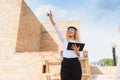 Female construction engineer. Architect with a tablet computer at a construction site. Young Woman looking, building Royalty Free Stock Photo