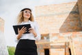 Female construction engineer. Architect with a tablet computer at a construction site. Young Woman looking, building Royalty Free Stock Photo