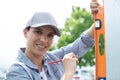 female construction worker checking vertical level wall Royalty Free Stock Photo