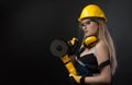 Female construction worker in a hard hat with angle grinder over black background Royalty Free Stock Photo