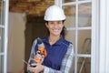 Female construction worker holding screwdriver handtool and cordless screwdriver