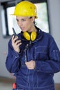 female construction worker relaying directions on walkie talkie Royalty Free Stock Photo