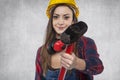 Female construction worker shows a big hammer Royalty Free Stock Photo