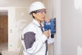 female construction worker smoothing wall surface