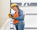 Female construction worker taking measurement