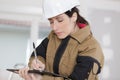 Female construction worker taking notes at construction site Royalty Free Stock Photo