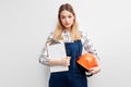 female constructor builder holding orange helmet and paper clipboard posing at camera