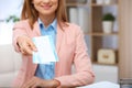 Female consultant holding tickets in travel agency, closeup
