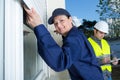 Female contractor installing window shutter Royalty Free Stock Photo