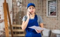 Female contractor with papers talking on phone at construction site Royalty Free Stock Photo