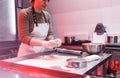 a female chef is working with a dough in the kitchen at a restaurant. beautiful red lighting Royalty Free Stock Photo