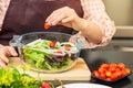 Female cook making fresh salad in her home cooking, various vegetables on table Royalty Free Stock Photo