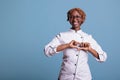 Female cook making heart symbol with hands