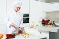 Female cook is making salad on her work place in the kitchen Royalty Free Stock Photo