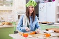 Female cook wearing Chef s hat and gloves making Japanese sushi rolls, smiling, looking at camera in the kitchen Royalty Free Stock Photo