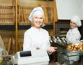 Female cooks with fresh and tasty bread in bakery