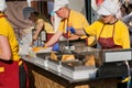 Female cooks in uniform of fast-food restaurant cooking fried food