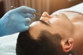 Female cosmetician using blackhead remover