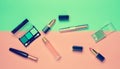 Female cosmetics for make-up layout on a pastel background. Cosmetic shadows, make-up brush, eyeshadow lipstick, perfume bottle. Royalty Free Stock Photo