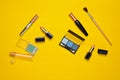 Female cosmetics for make-up layout on a yellow background. Cosmetic shadows, make-up brush, eyeshadow lipstick, perfume bottle. Royalty Free Stock Photo