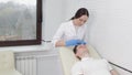 A female cosmetologist in the clinic injects carbon dioxide into the skin of a male client to increase blood flow in the