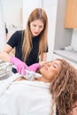 Woman cosmetologist performs a smas-lifting procedure on the decollete area